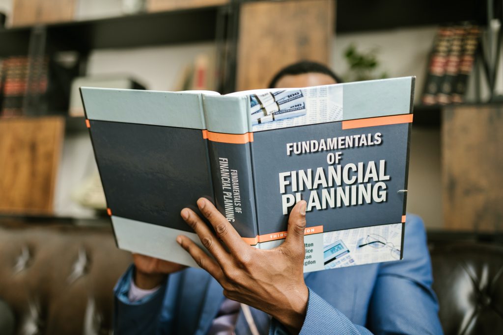 man holding a book titled Financial planning